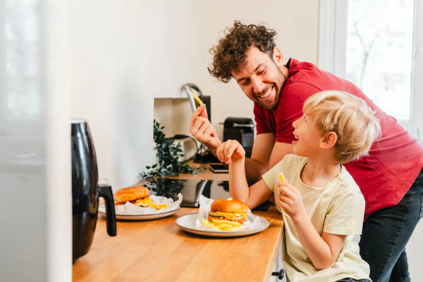 istock Father and son eating hamburger at home 2153111530