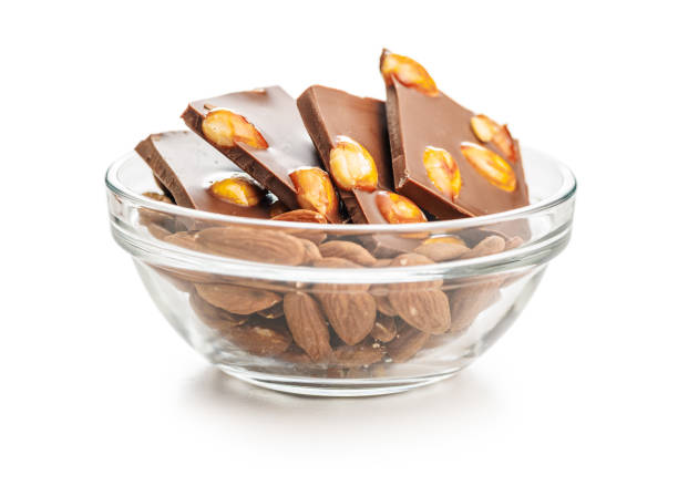 istock Broken chocolate bar with almonds in bowl isolated on white background. 2153114311