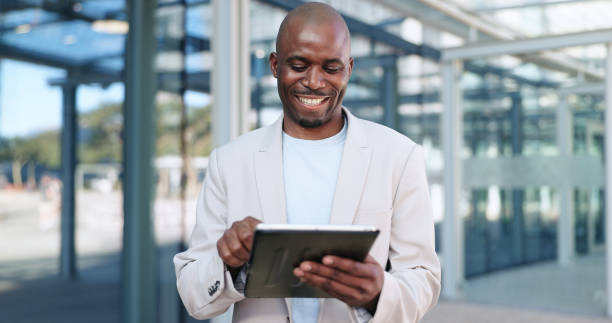 istock Black man, tablet and typing in city, commute and online, digital and technology. Working, cape town and busy in urban area, office buildings and businessman for networking and checking email 2153114712