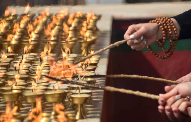 istock Candles in a temple are lit by hands 2153117343