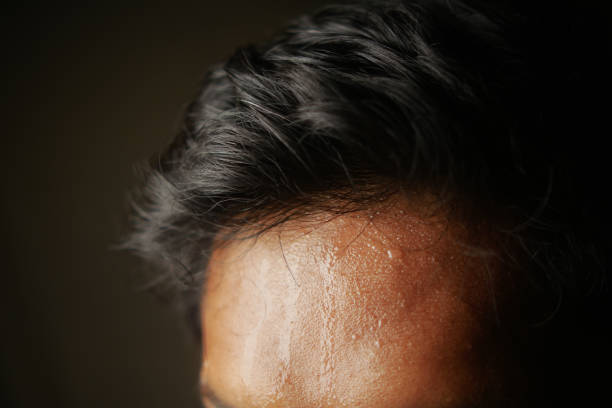istock closeup of sweat on forehead against dark background , 2153118300