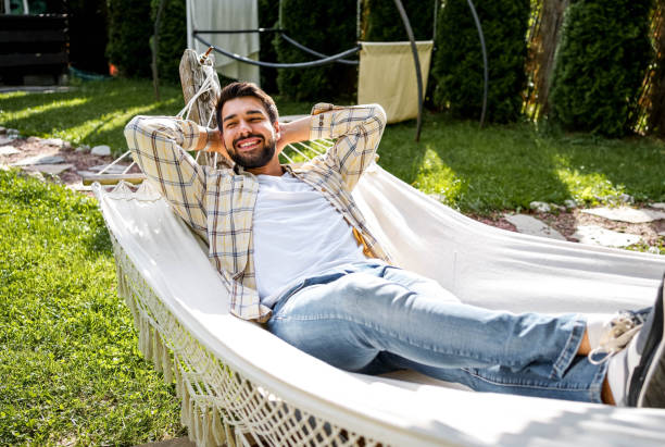 istock Man relaxing in a hammock in the backyard 2153119763