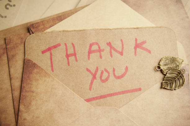 thank you message and envelope on wooden table.