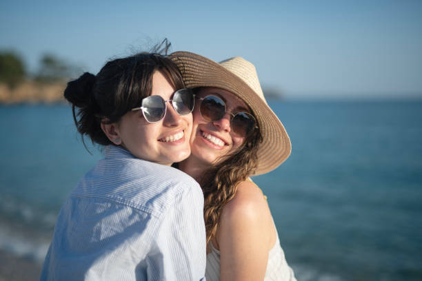 Young friends women embraced on the beach