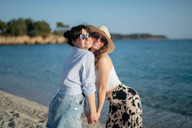 Photo of female friends walking at the beach and enjoying their summer vacation.