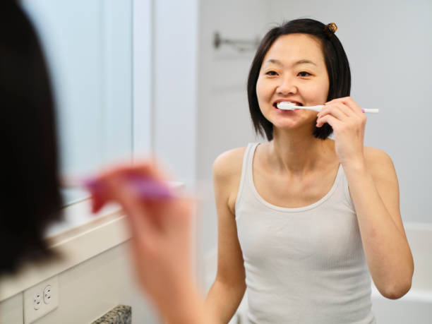istock Woman Brushing Teeth in a Home Bathroom 2153121393