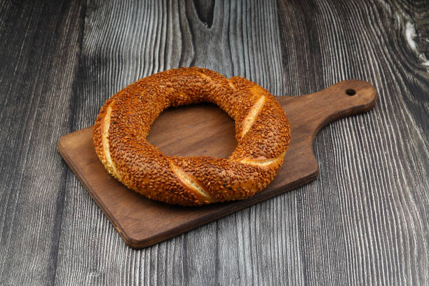 Turkish traditional bagel / simit with sesame on rustic table, turkish breakfast pastry concept