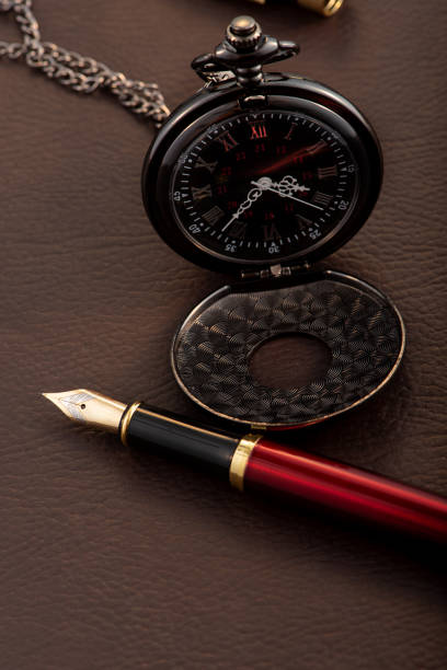 istock Fountain pen and antique pocket watch on leather surface, selective focus 2153132601
