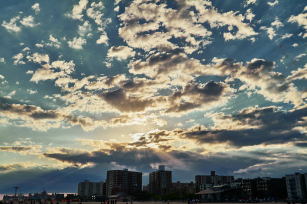 Light rays over coney island peeking through the clouds in the evening