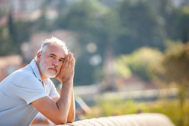 istock Pensive alone mature man looking at view 2153141438