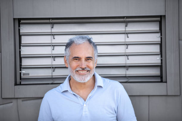 istock Serene mature man portrait against metallic grey wall 2153141456