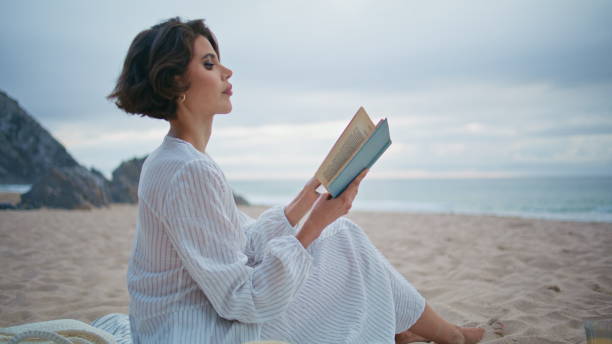 istock Outdoor woman enjoy book at cloudy seashore closeup. Romantic lady rest beach 2153143473