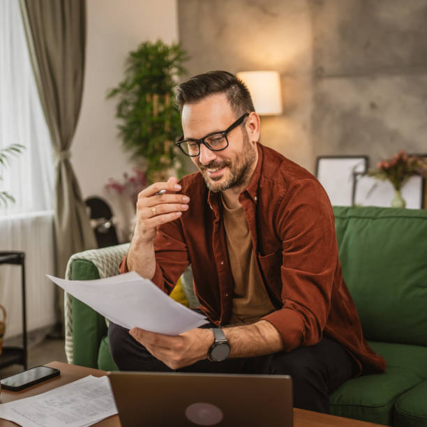 istock Adult caucasian man work from home on laptop and hold documents 2153147663