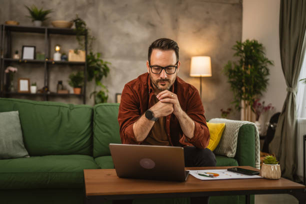 istock Adult caucasian man sit on sofa and work from home on lap top 2153147886