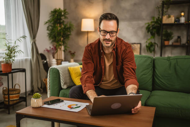 istock Adult caucasian man sit on sofa and work from home on lap top 2153147940