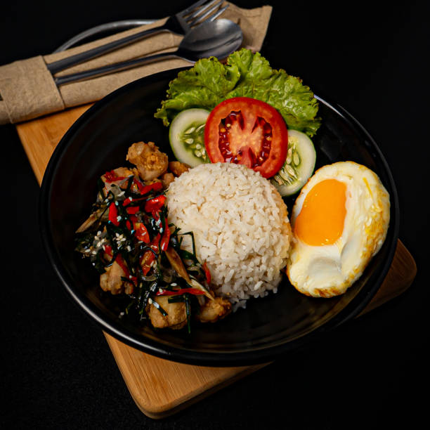 istock Chicken Rice bowl sambal matah on a wooden cutting board 2153149668