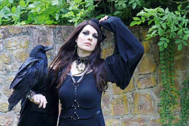 istock A woman dressed as a witch with a large raven on her hand 2153151838