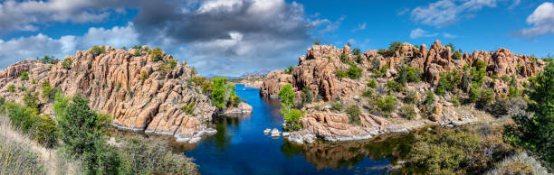 The Granite Dells are a geological feature characterized by exposed granite rock formations that have been sculpted by wind and water over millions of years into unusual shapes and patterns.  The term “dells” refers to the valleys or low areas between the granite formations.  Nestled among these natural wonders lies Watson Lake, a reservoir formed in 1915 when early settlers dammed Granite Creek. This juxtaposition of geological history and human intervention creates a serene oasis, inviting visitors to ponder the passage of time and marvel at the forces of nature.  Watson Lake and the Granite Dells are in Prescott, Arizona, USA.