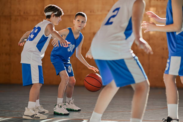 istock Junior basketball team in action practicing game playing at court. 2153156171