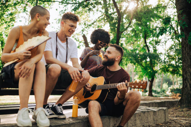 istock Interracial street performers sitting in a park and jamming. 2153156297