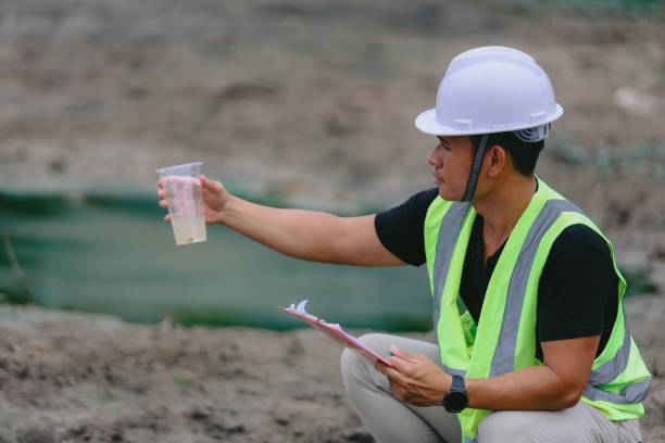 istock Environment Issue concept. Team of Scientists in protective suits and masks took a sample of water for analysis. Environment Issue concept 2153156586