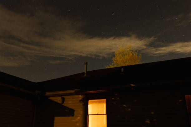 A beautiful night sky glimmering above a warm home.