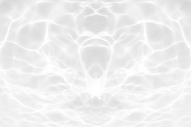 Bluewater waves on the surface ripples blurred. Defocus blurred transparent blue colored clear calm water surface texture with splash and bubbles. Water waves with shining pattern texture background.