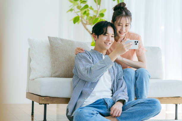 istock Couple relaxing at home with smartphone in hand 2153161468