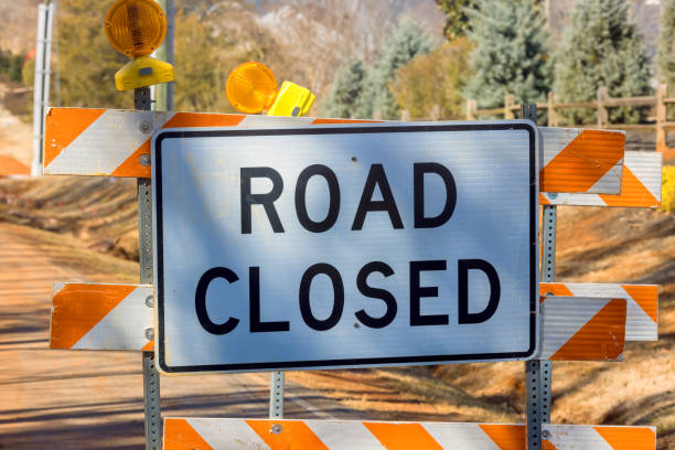 istock There is orange striped road closure sign near an ongoing construction project that preventing vehicles from a driving 2153164936