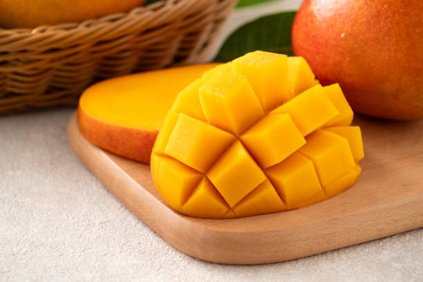 istock Fresh slice cut juicy mango on gray table background with leaf. 2153167740