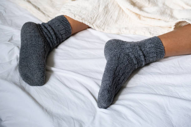 istock Woman wearing woolen socks and resting in bed. 2153173309