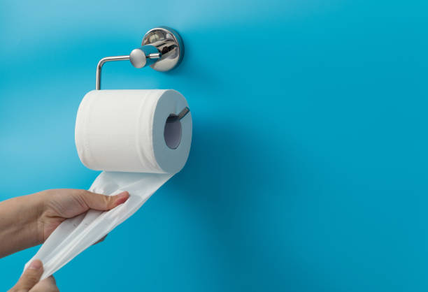 Woman hand pulling toilet paper.