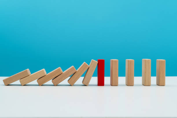 istock Red wooden block stop other falling dominos 2153173493