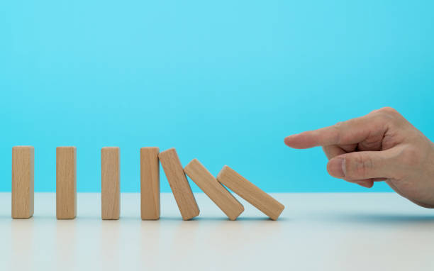 istock Human finger pushing domino pieces 2153173532