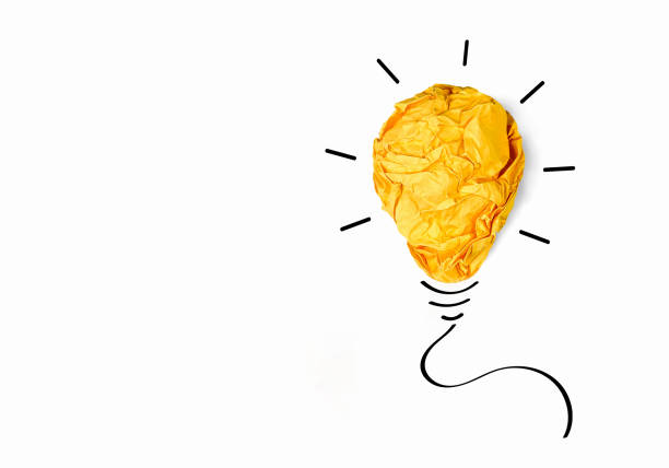 istock Crumpled colored paper in shape of yellow light bulb isolated on white background 2153174165