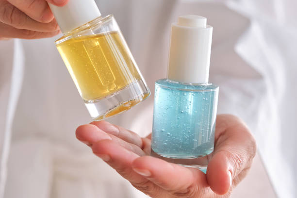istock Two yellow and blue serums in a womans hands in a robe. 2153175944
