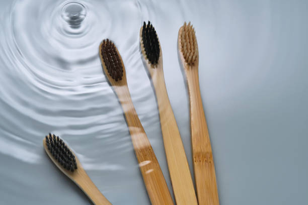 istock Natural bamboo toothbrushes in water on a blue background. 2153176321