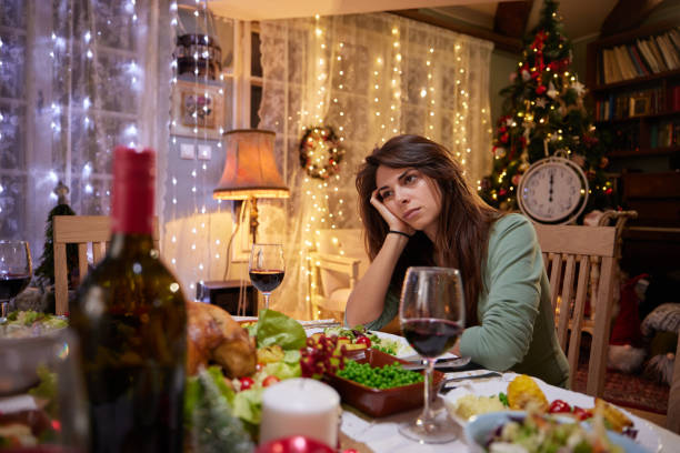 Sad woman alone on New Year's Eve at dining table.