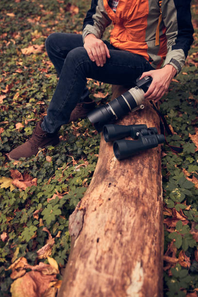 istock Man using binoculars and camera for bird and animal watching in nature. 2153181873