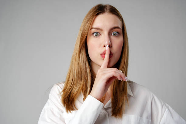 istock Young Woman Making a Hush Gesture on gray background 2153183655