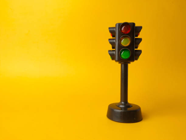 istock Mini traffic lights on a yellow background 2153184309