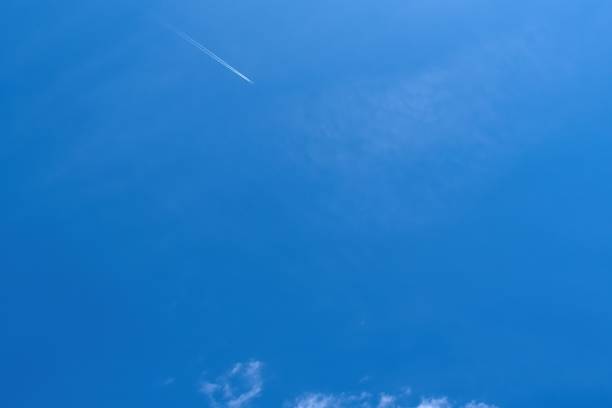 istock Airplane with contrails in the blue sky. 2153184622