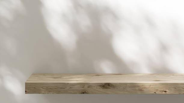 istock Wood plank shelf in dappled light sunlight on white wall 2153186896