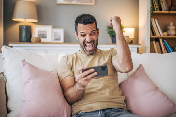 istock Mature man playing video games on his phone 2153189220