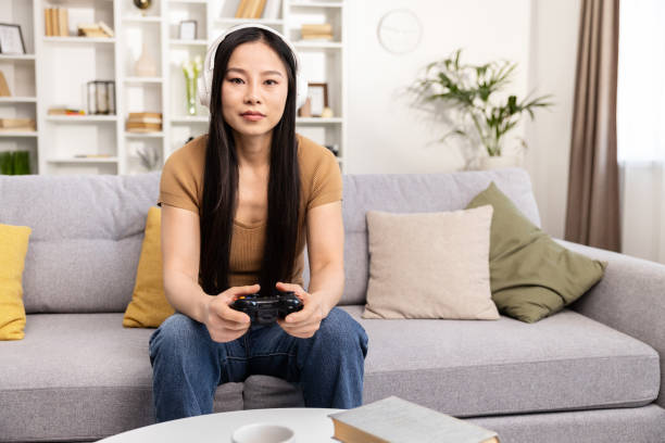 istock Focused Woman Playing Video Game on Couch at Home 2153190823