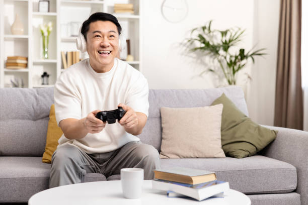 istock Happy Man Playing Video Games on Couch at Home 2153190853
