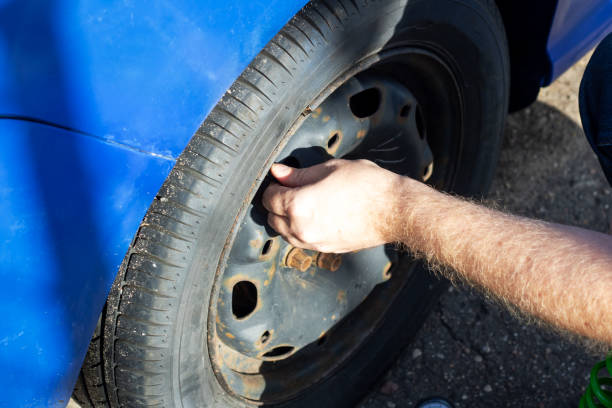 istock A man inflating the wheel of a blue car 2153193157