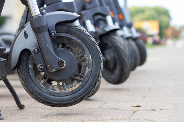 istock Wheels of many scooters stand on sidewalk 2153193634