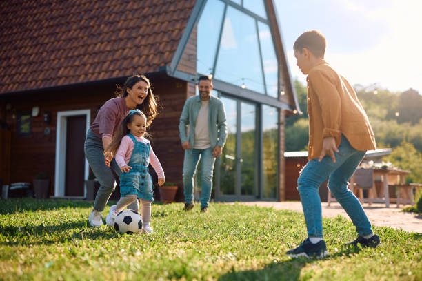 istock Carefree family having fun while playing with a ball in the backyard. 2153194001