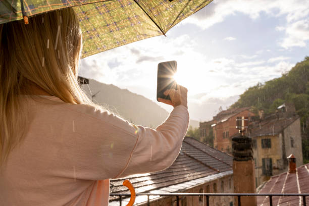 Mature woman enjoys sun shower Mature woman enjoys sun shower on roof top terrace in medieval town reach destination stock pictures, royalty-free photos & images